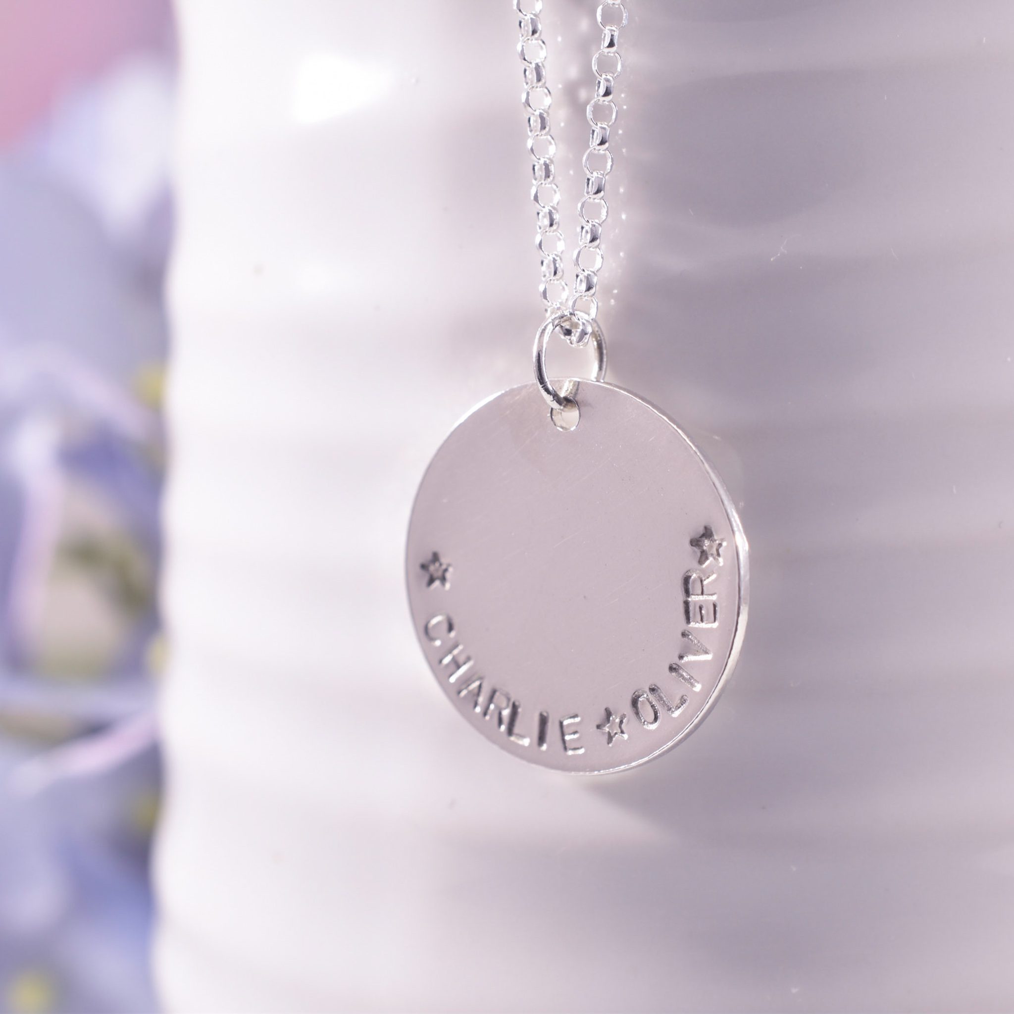 Silver disc necklace with personalised hand stamped names around the edge