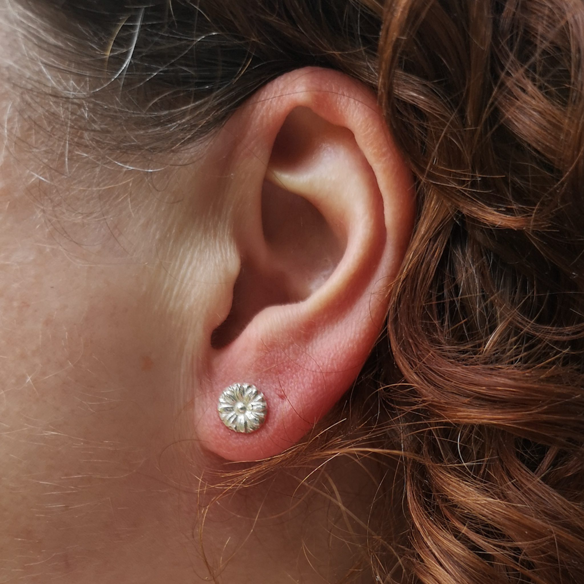 Sterling silver 3d flower stud earrings show in the ear lobe
