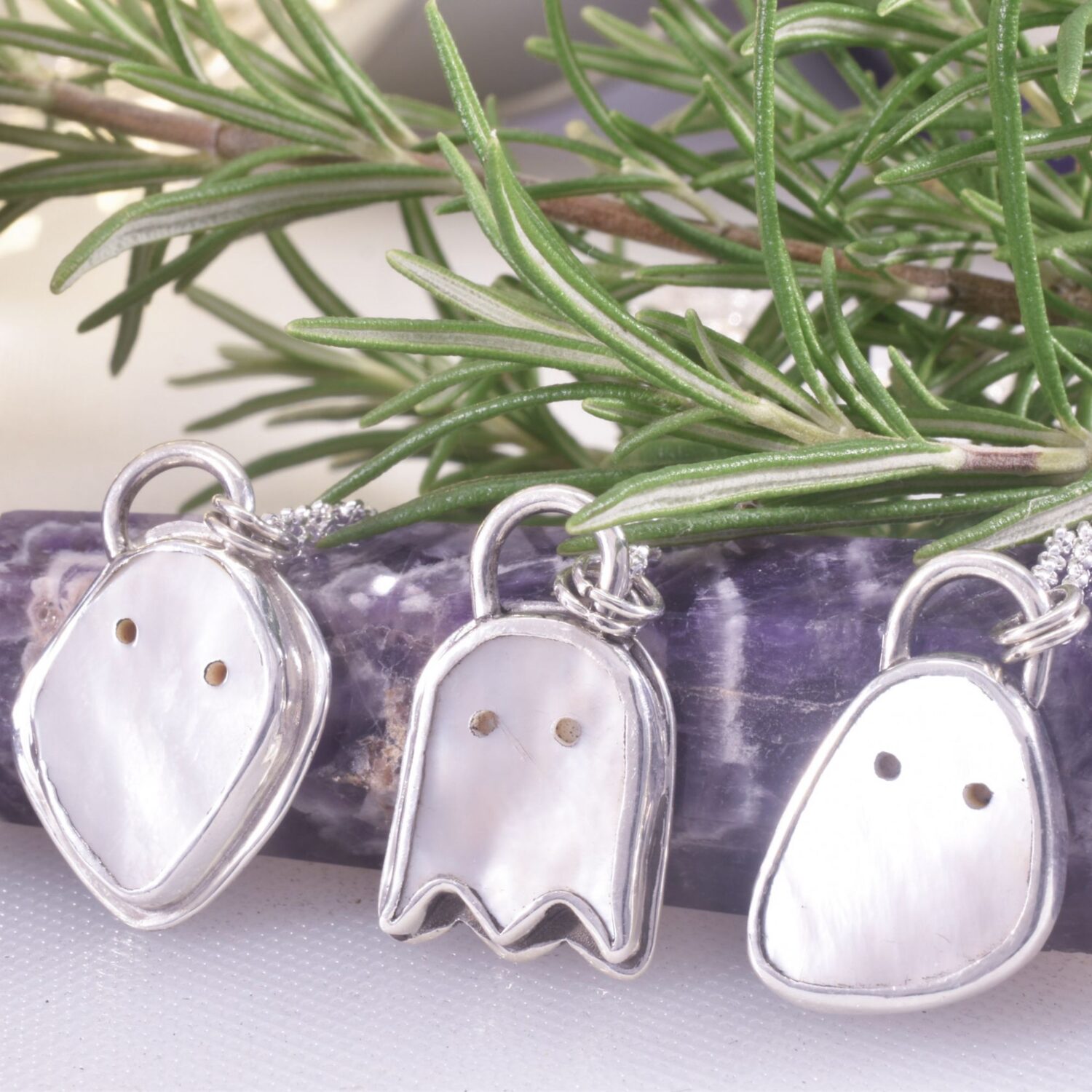 A trio of Mother of pearl cure spooky ghost pendants, each slightly different in style, all with 'boo' and stars and moons to the reverse.